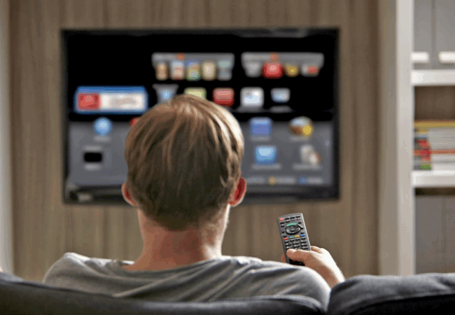 A man sitting on a couch watching TV